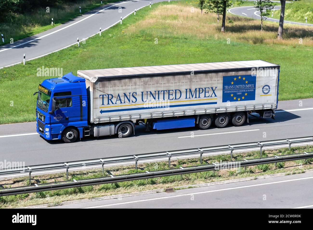 Trans United Impex MAN TGX truck with curtainside trailer on motorway. Stock Photo