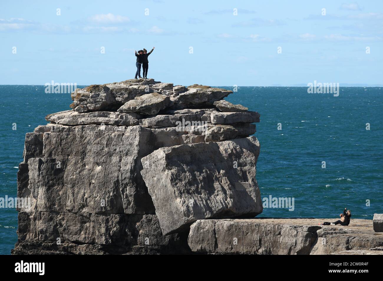 Portland, Dorset. 26th September 2020. Uk Weather. Tourists climb Pulpit Rock on a windy afternoon at Portland Bill. Credit Stuart Martin/Alamy Live News Stock Photo