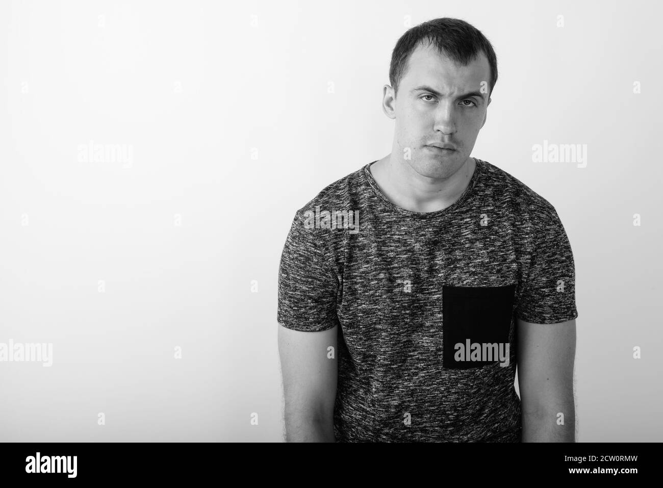 Studio shot of young muscular man looking tired against white background Stock Photo