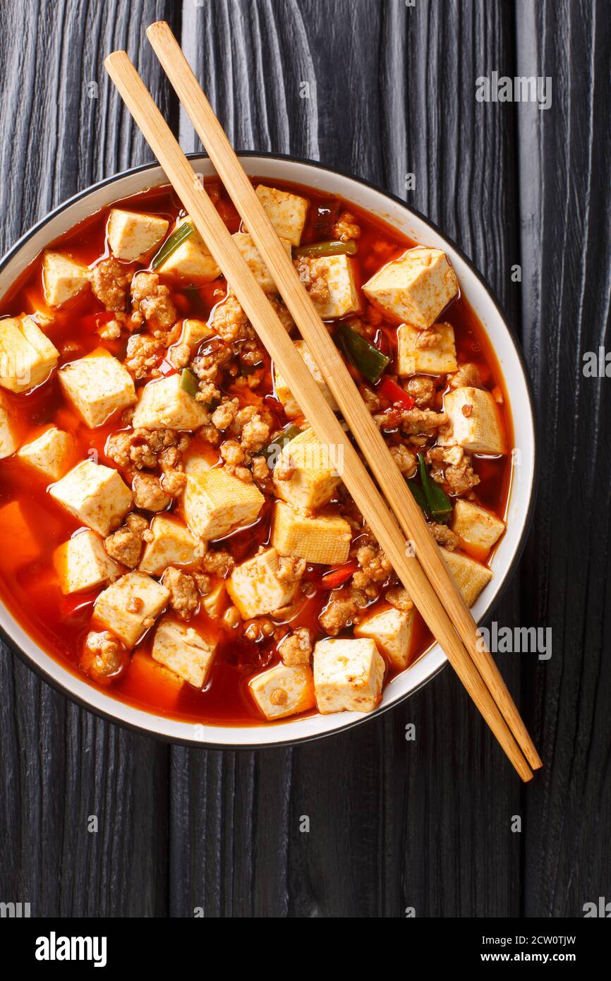 Authentic Chinese style mapo tofu is one of the branding dishes of Szechuan cuisine closeup in the plate on the table. Vertical top view from above Stock Photo