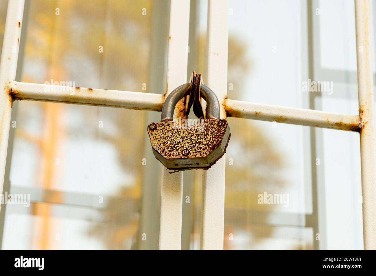 the lock hangs on a metal lattice on the window. Thief protection Stock Photo