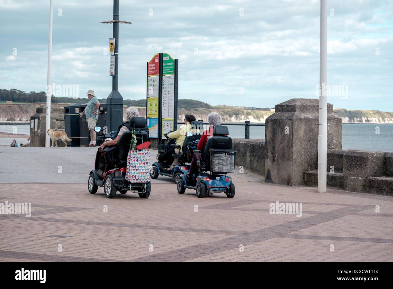 Three women on mobility scooters on the promenade at Bridlington East Yorkshire Stock Photo