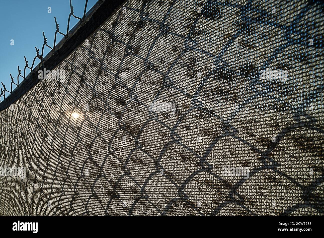 Dirty screen on chain link fence Stock Photo