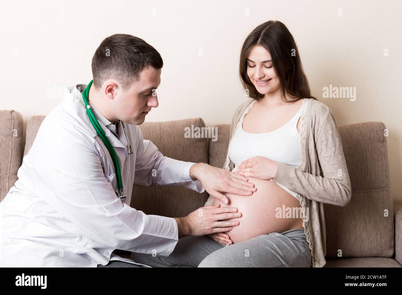 Doctor touching stomach young patient hi-res stock photography and