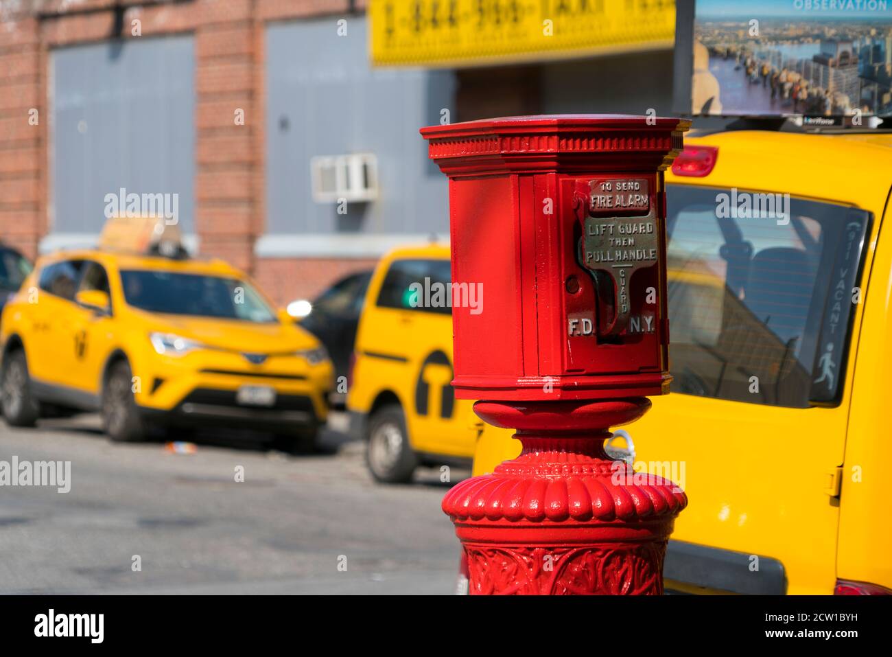 Fire Alarm stands in front of Yellow taxis at Queens Long Island City