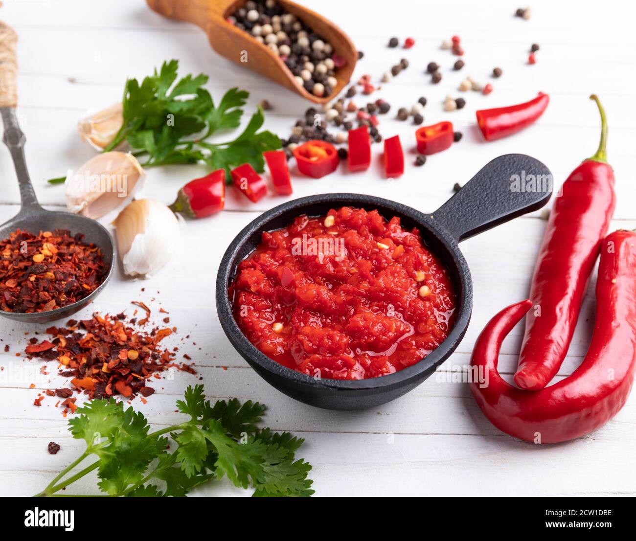homemade red hot sauce pepper ingredients, on a white wooden surface, spices, close up Stock Photo