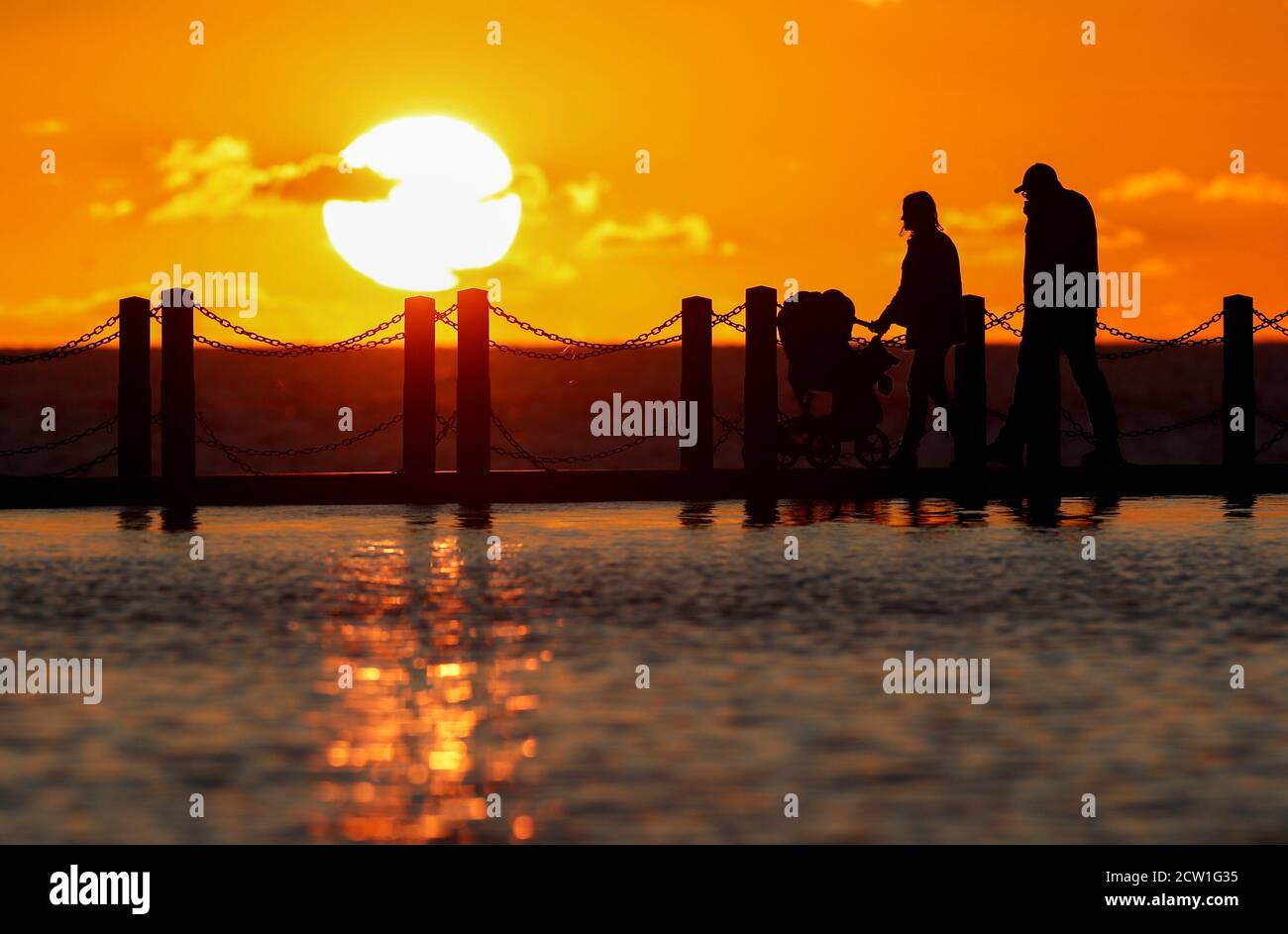 People are seen at Marine Lake as the sun sets over the Bristol Channel, Weston-super-Mare, Britain, September 26, 2020. REUTERS/Peter Cziborra Stock Photo