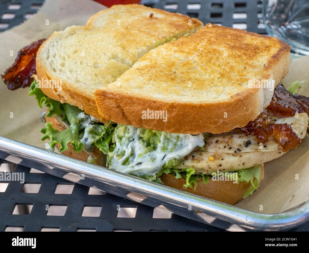 Chicken sandwich with beacon on toasted braed and lettace on a plate