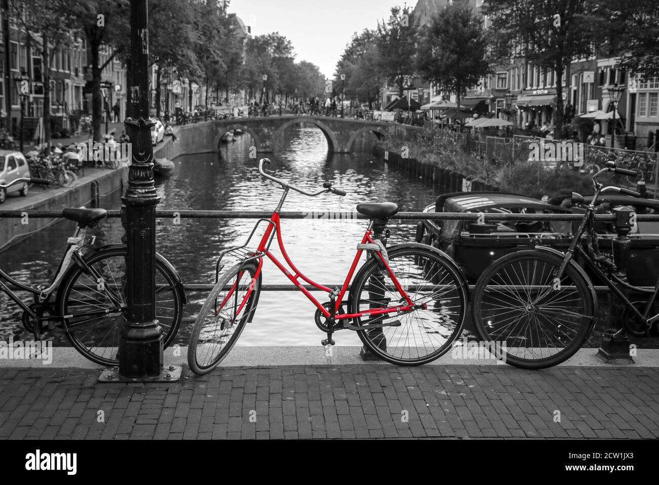 A picture of a red bike on the bridge over the channel in Amsterdam