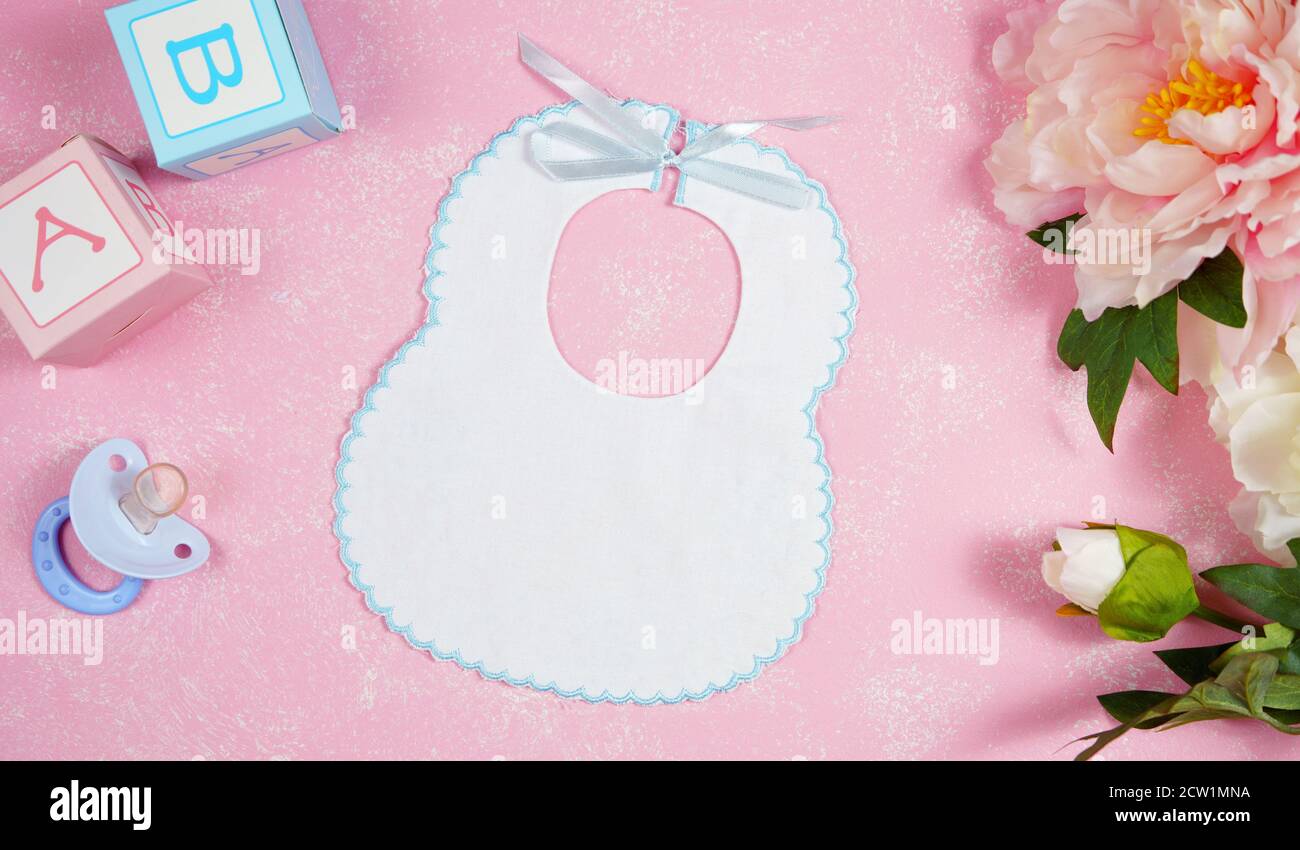 Baby bib nursery clothing mom bloggers desktop mockups with peonie floers on pink textured background. Top view blog hero header creative composition Stock Photo