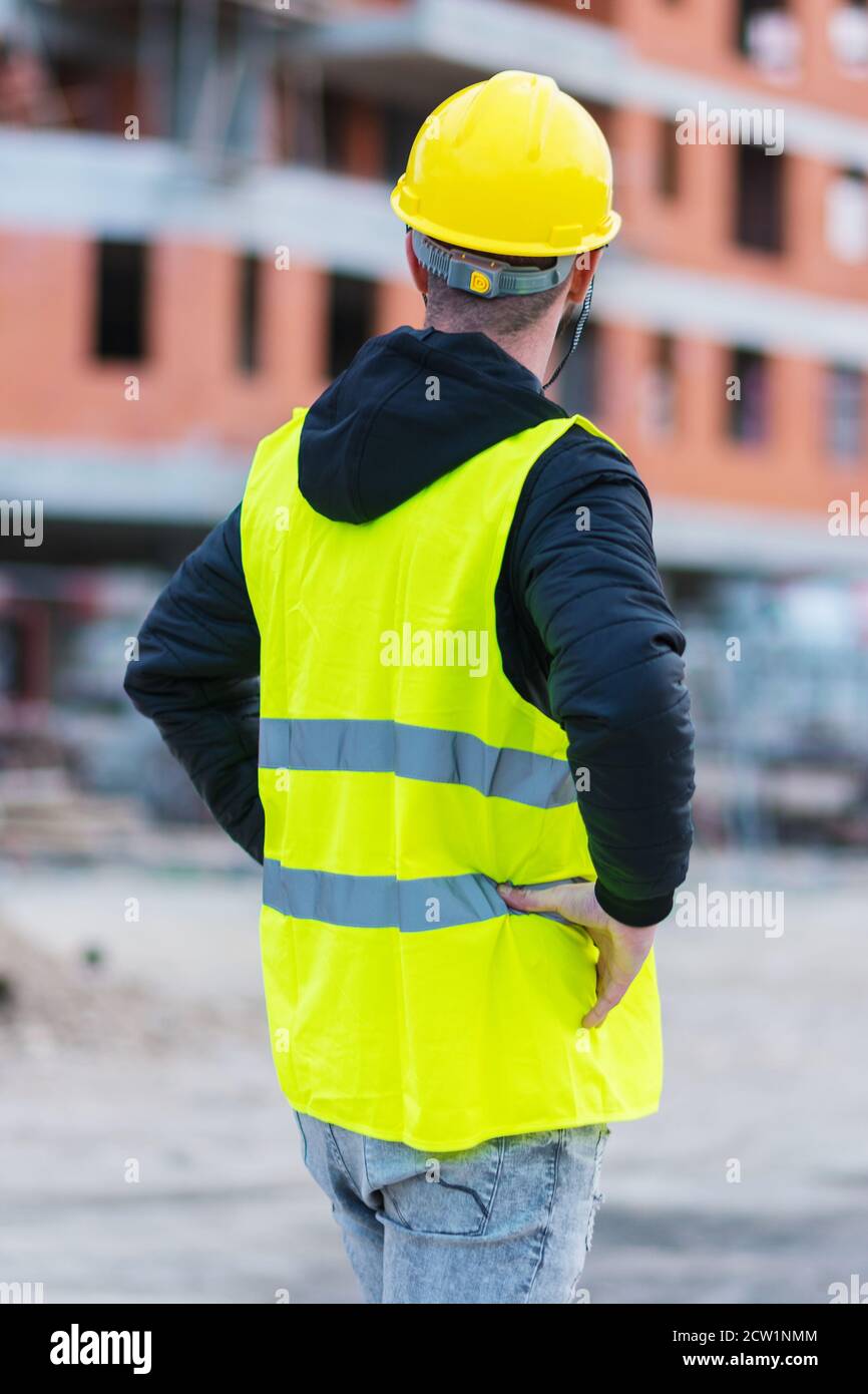 An engineer posing in front of building construction he is working of