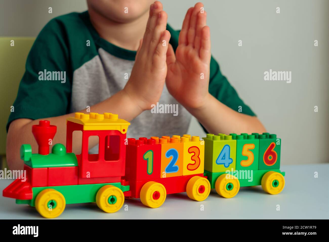 Child playing with a train, blocks of numbers. Educational toys for