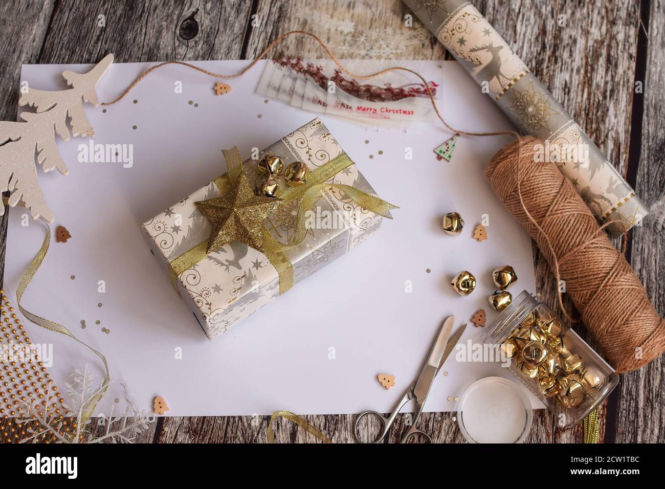 Elegant flatlay layout with space for lettering, preparing for Christmas, with gift box, scissors, snowflake on wooden background.  Stock Photo