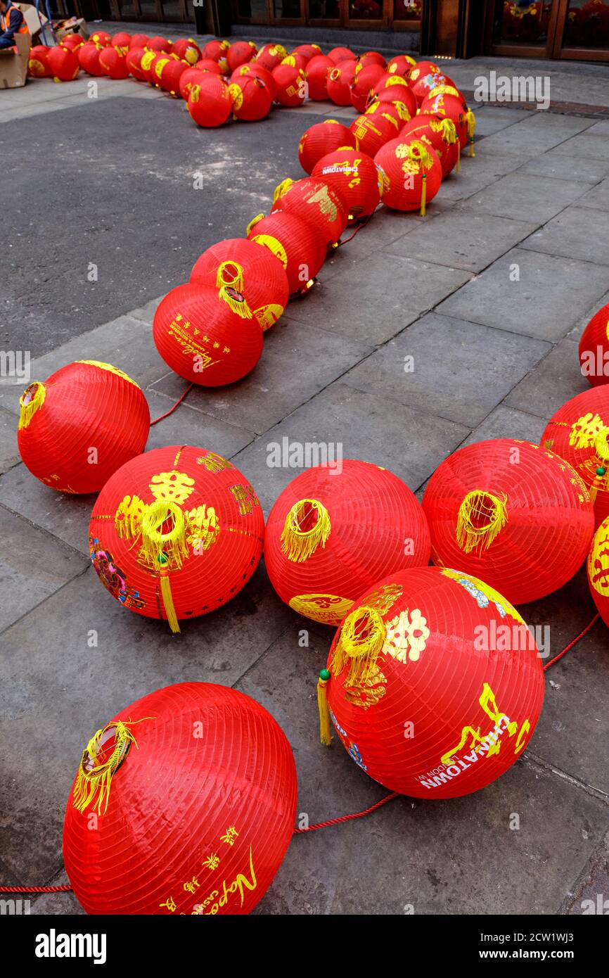 Workers prepare to hang festive Chinese lanterns in Chinatown, London, United Kingdom. Stock Photo