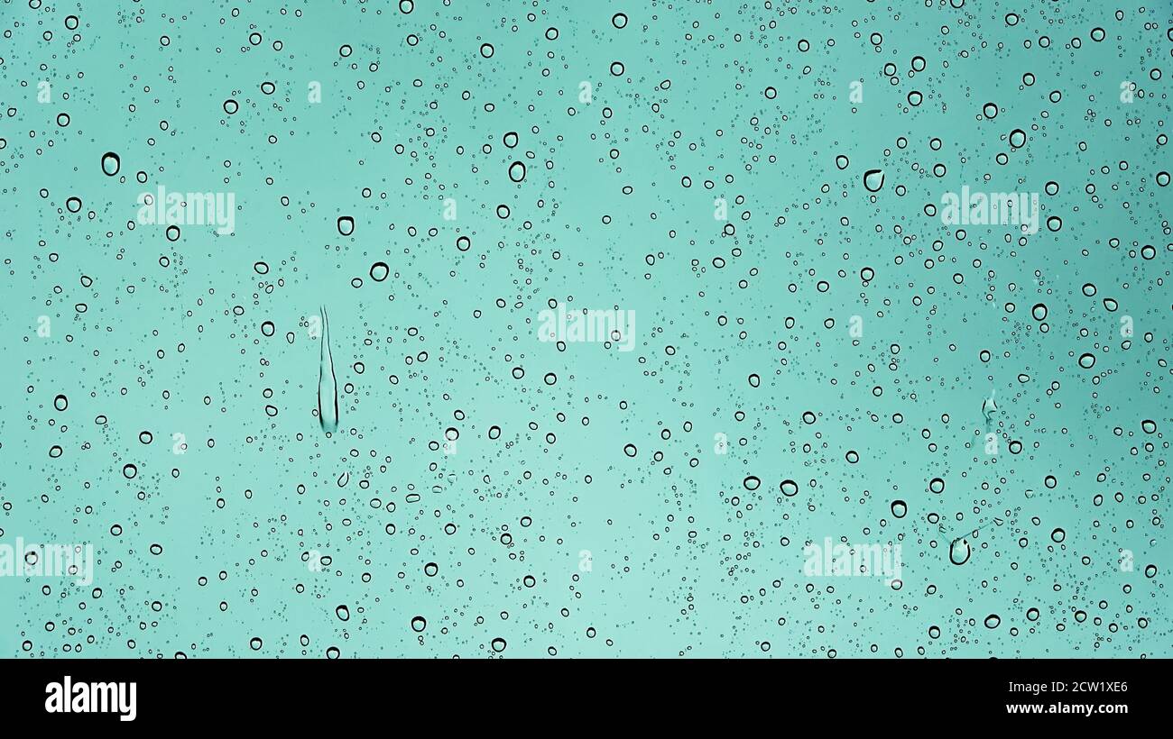 Rain drops running down a car window in a close up view Stock Photo