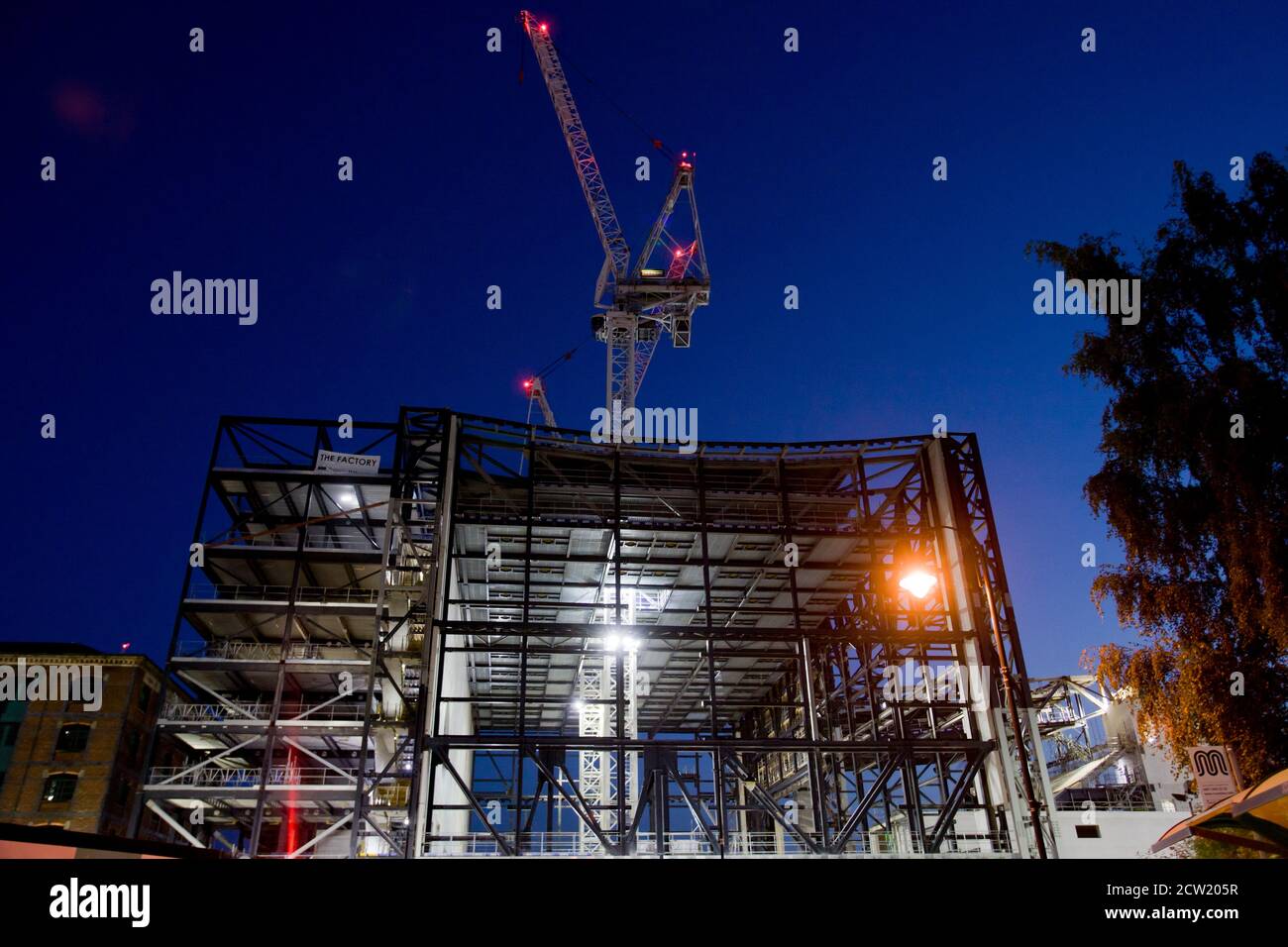 Building site lit up at night. Construction, cranes, new builds, gentrification, Manchester, girders, downtown, city centre, luxury flats, UK Stock Photo