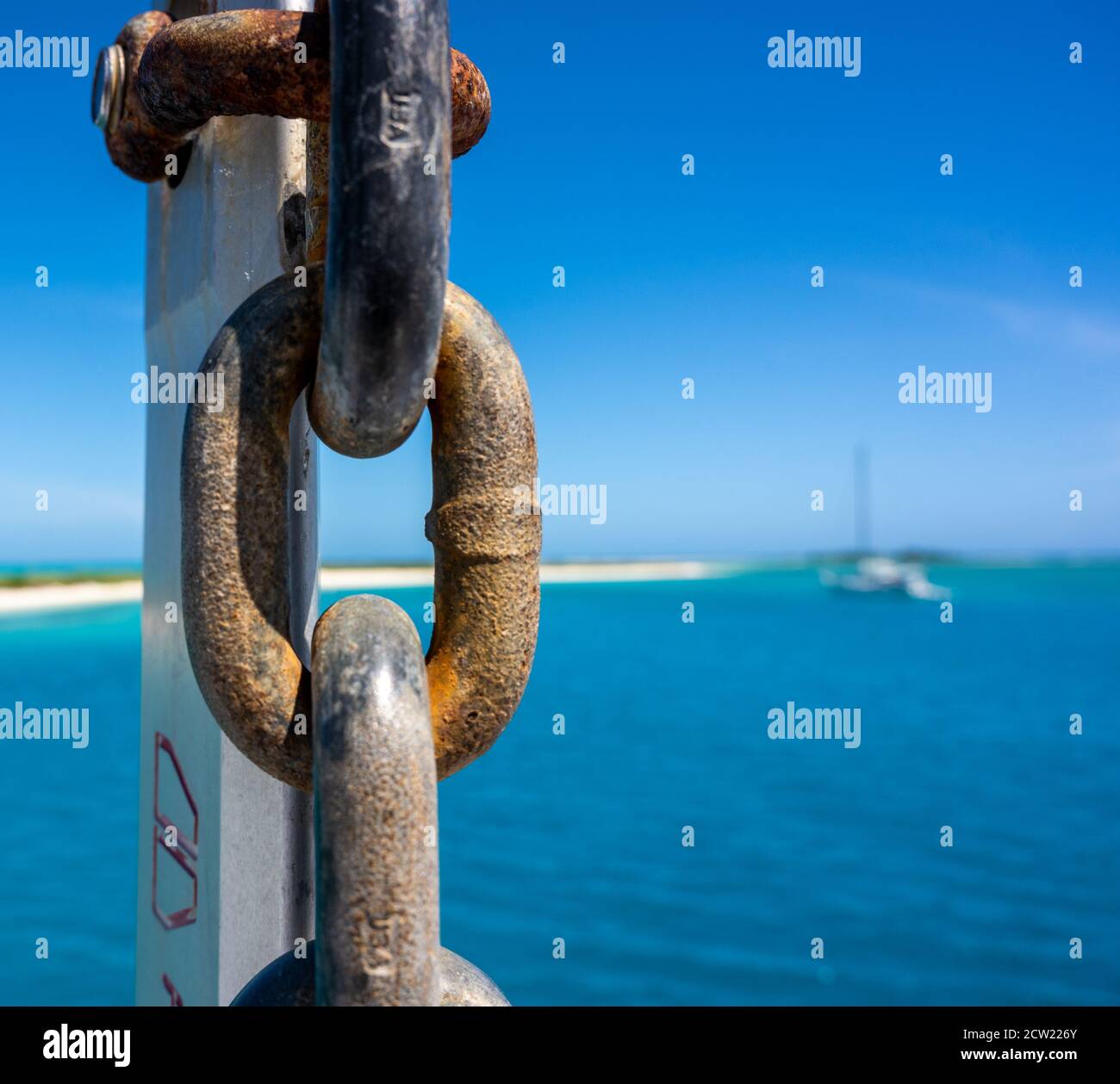 Anchor Chain Close Up with Blue Water Background in background Stock Photo