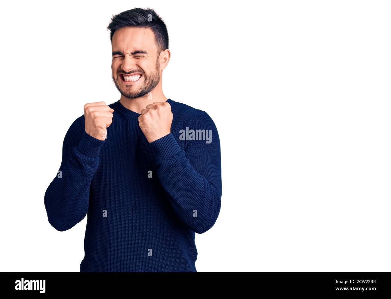 Young handsome man wearing casual clothes excited for success with arms ...