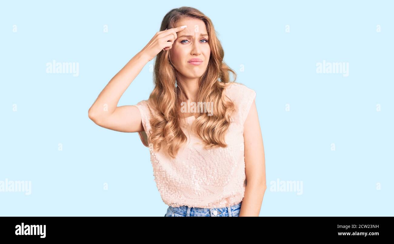 Young beautiful caucasian woman with blond hair wearing casual clothes  pointing unhappy to pimple on forehead, ugly infection of blackhead. acne  and s Stock Photo - Alamy