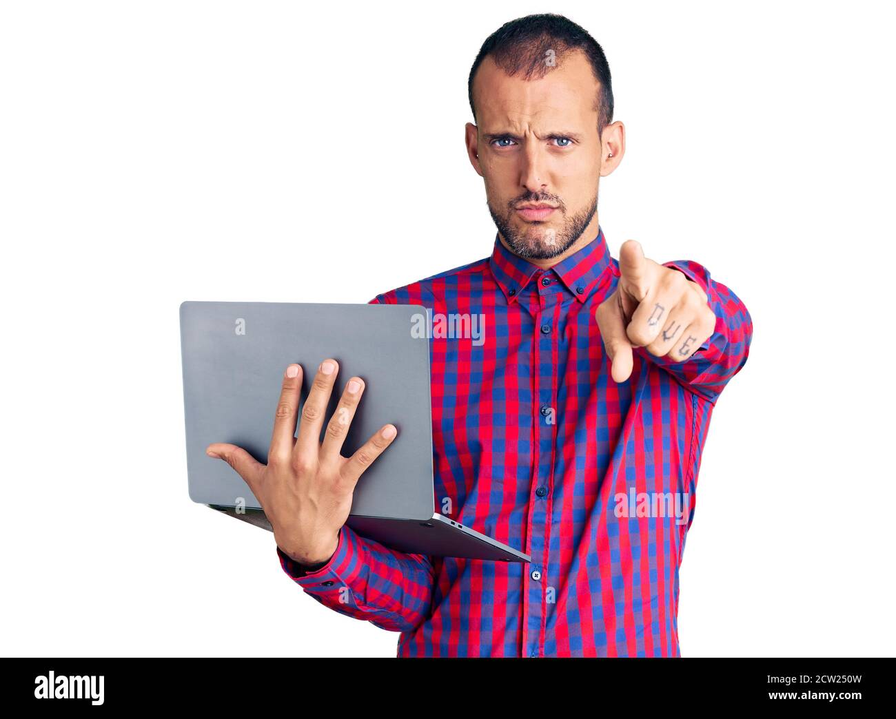 Young handsome man working using computer laptop pointing with finger ...
