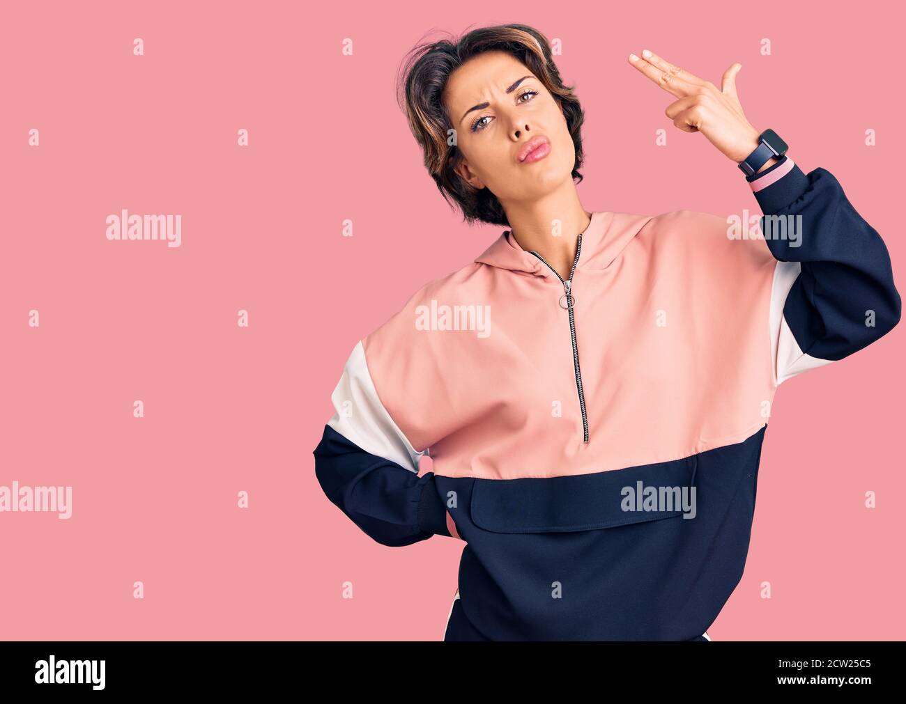 Young beautiful woman wearing sportswear shooting and killing oneself  pointing hand and fingers to head like gun, suicide gesture Stock Photo -  Alamy