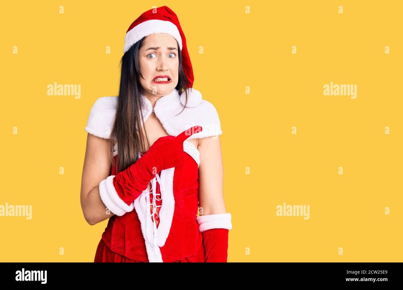 Young beautiful caucasian woman wearing santa claus costume pointing ...