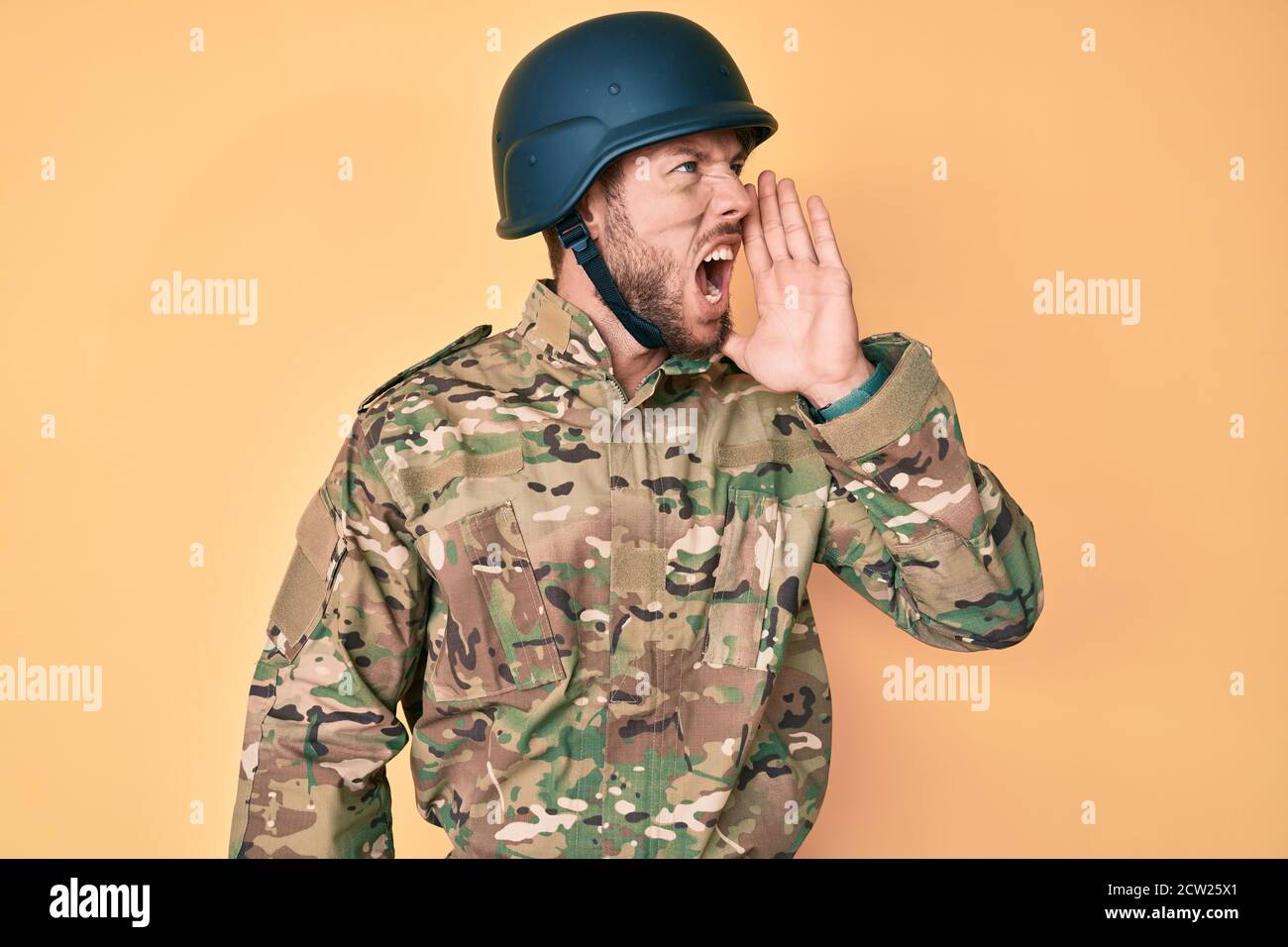 Young caucasian man wearing camouflage army uniform shouting and ...