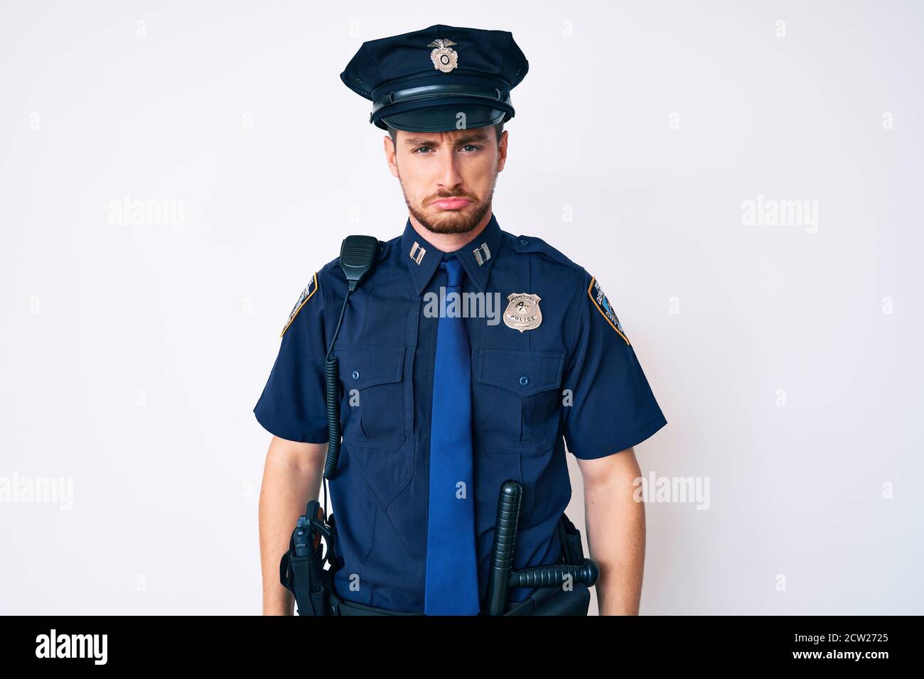 Young caucasian man wearing police uniform depressed and worry for distress, crying angry and afraid. sad expression. Stock Photo