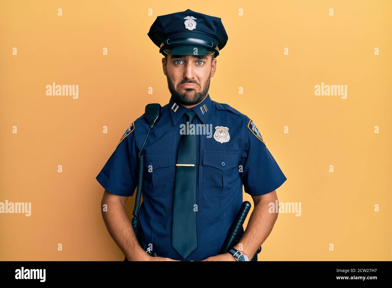Handsome hispanic man wearing police uniform depressed and worry for distress, crying angry and afraid. sad expression. Stock Photo