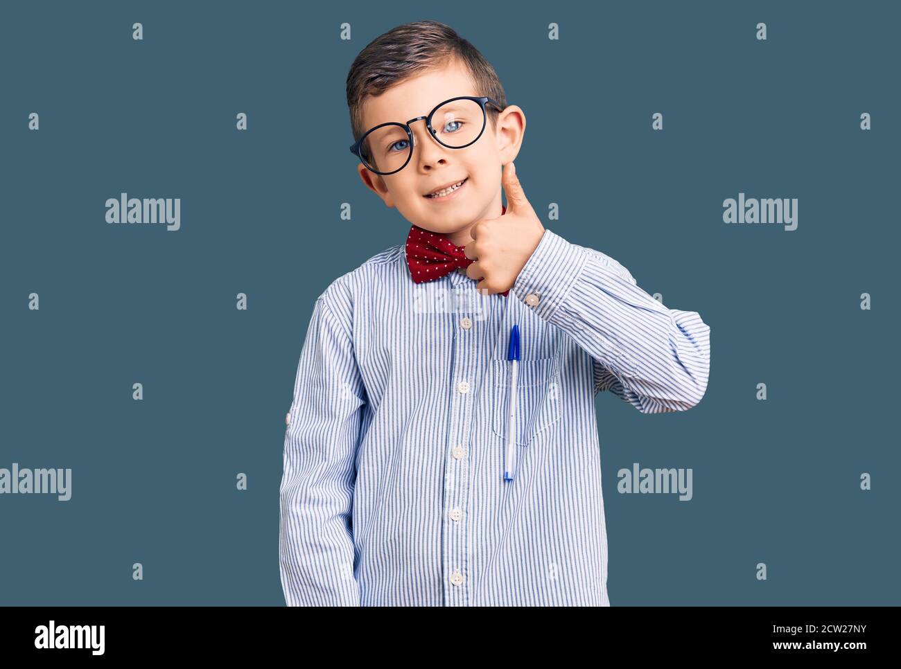 Cute blond kid wearing nerd bow tie and glasses smiling happy and ...
