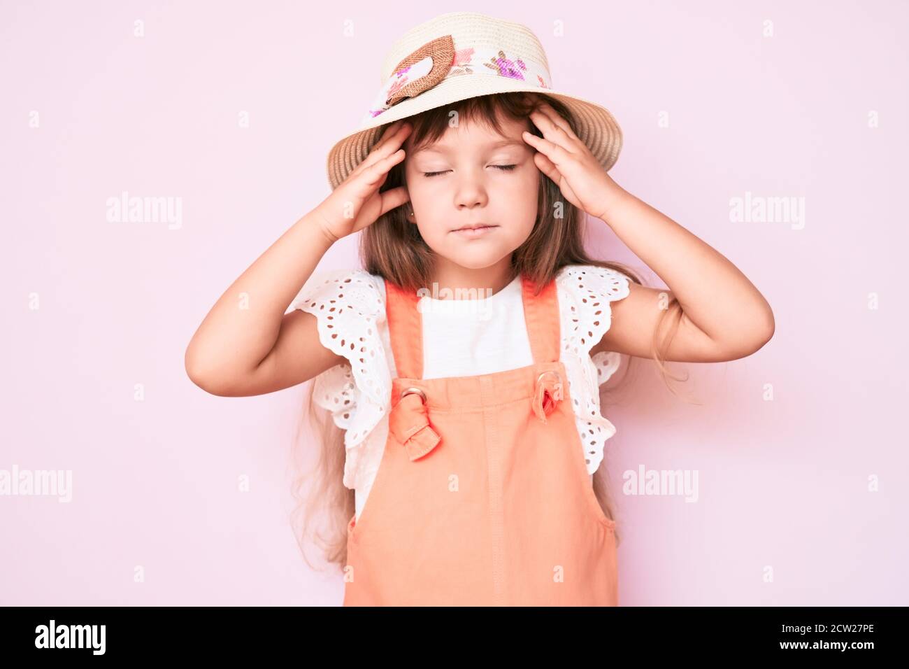 Little caucasian kid girl with long hair wearing spring hat with hand ...