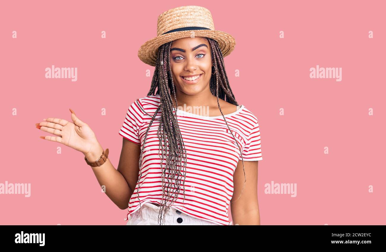 Young african american woman with braids wearing summer hat smiling ...