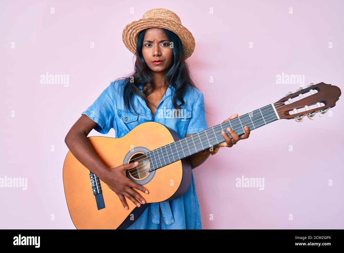Young indian girl playing classical guitar skeptic and nervous, frowning  upset because of problem. negative person Stock Photo - Alamy