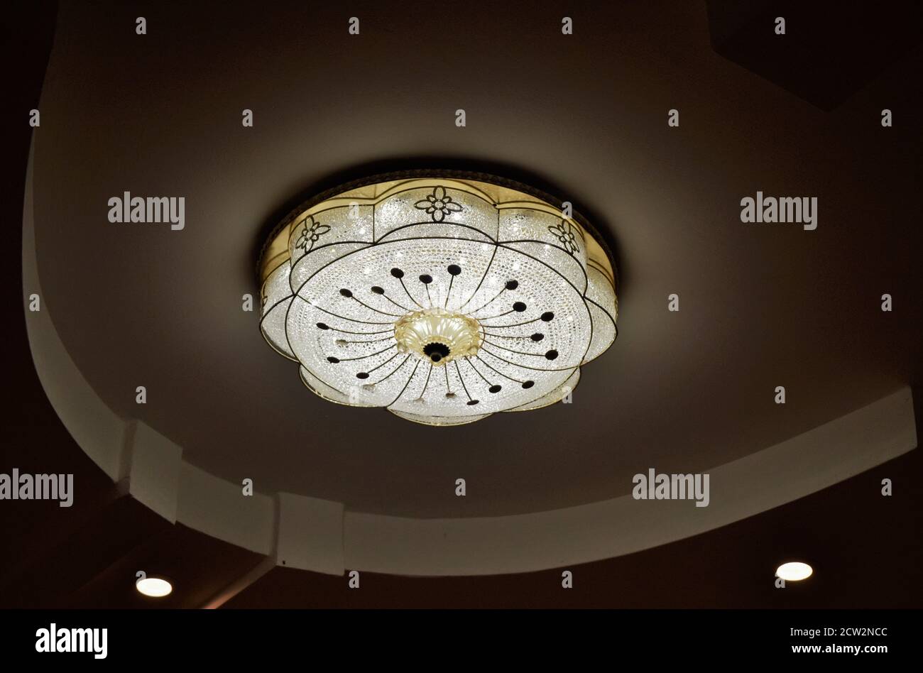 Round drop ceiling with lamps / lighting fixtures. Modern interior photo. Abstract architecture in shades of light gray / white colors. Stock Photo