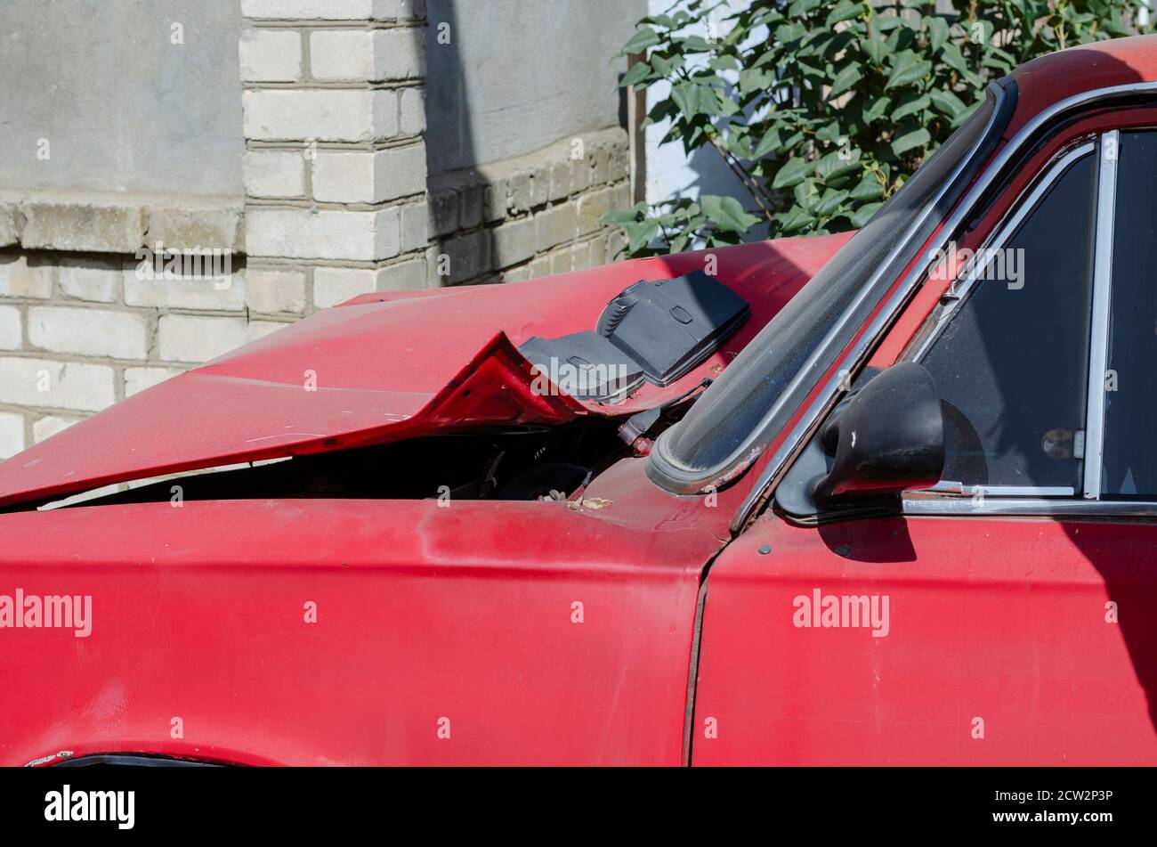 The front of the car after a road accident. Red sedan with significant ...