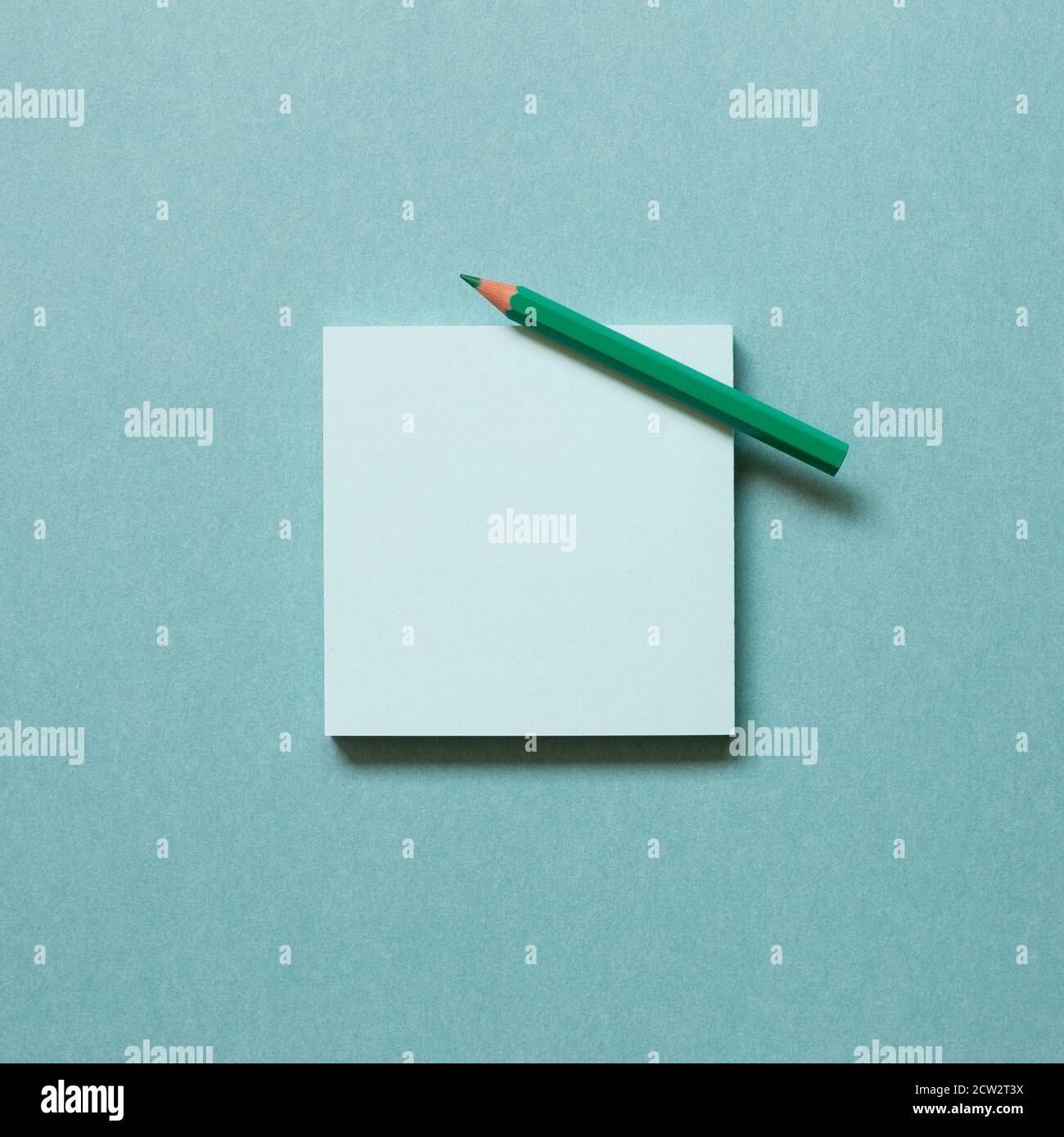 Green memo paper, sticky notes with colored pencil on green background. top view, copy space Stock Photo