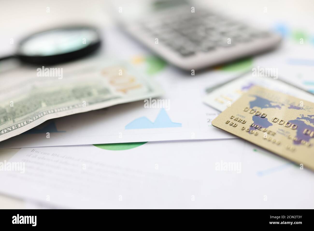On table american dollars plastic cards and calculator and magnifying glass. Stock Photo