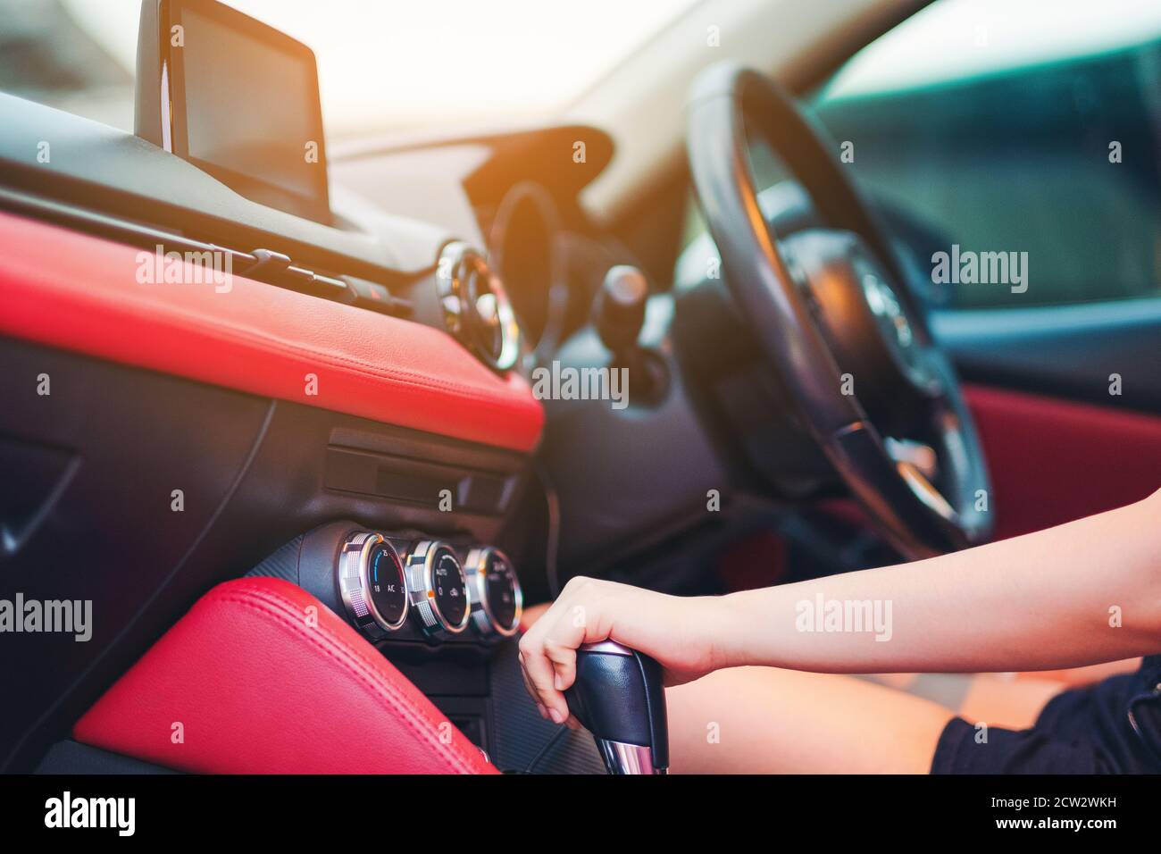 Woman driving, using a manual transmission stick shift. close up of