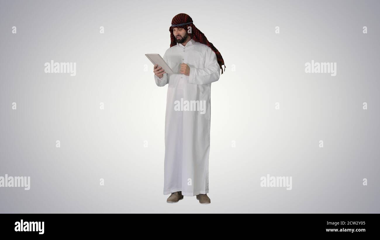 Arabic business man with tablet on gradient background. Stock Photo