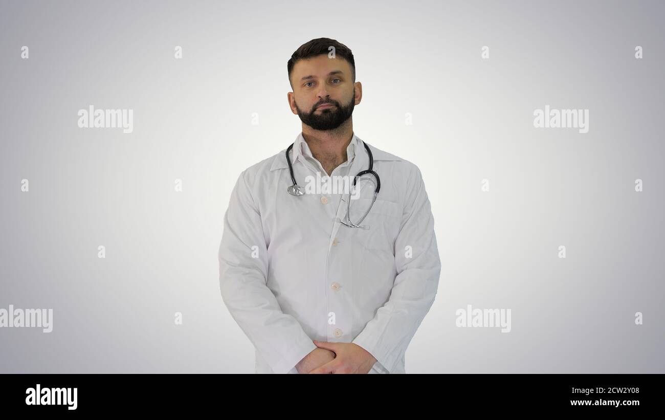 Doctor with a beard looking to camera on gradient background. Stock Photo