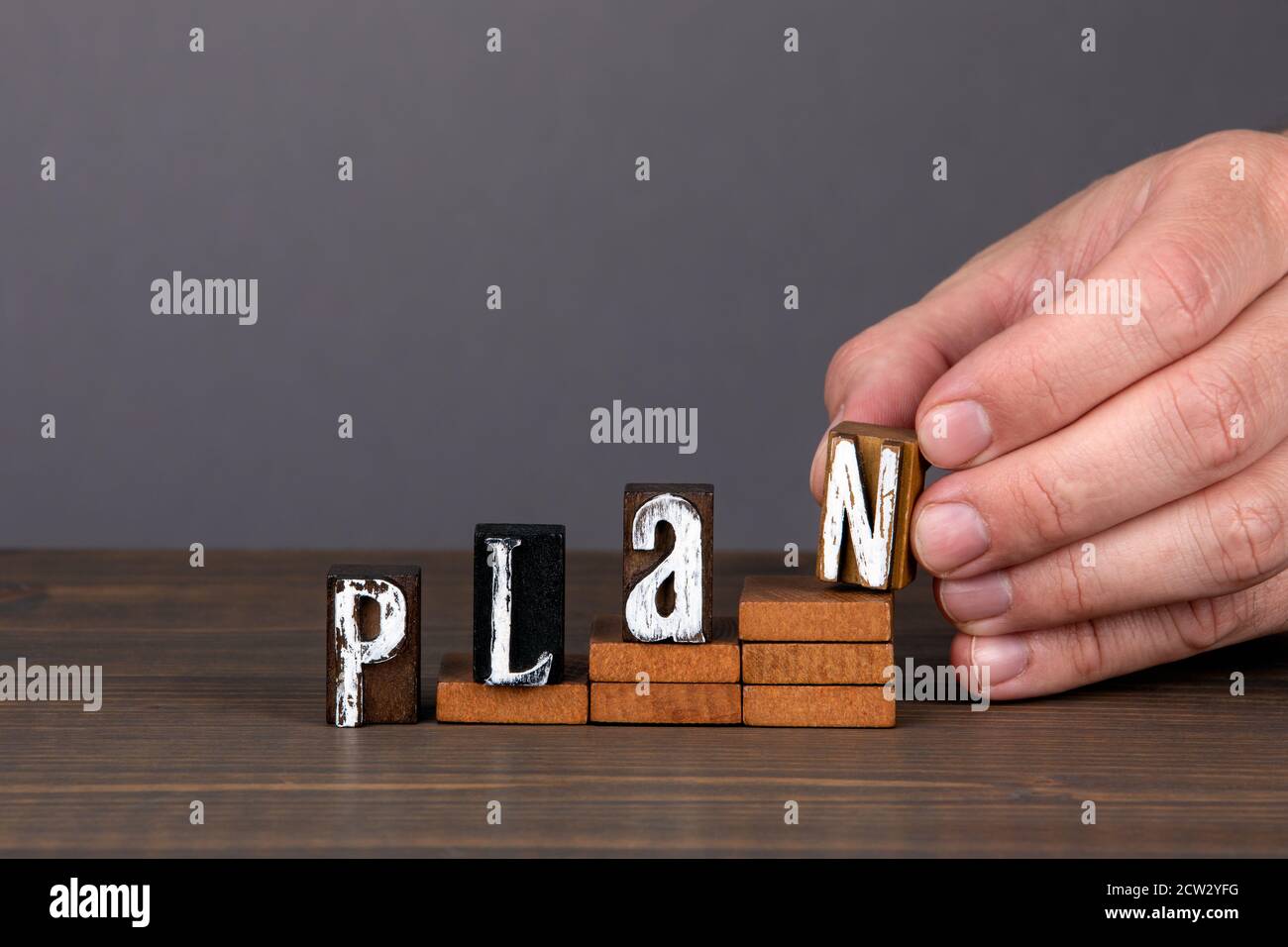 PLAN. Future, new year and business concept. Wooden alphabet letters on steps. Gray background Stock Photo