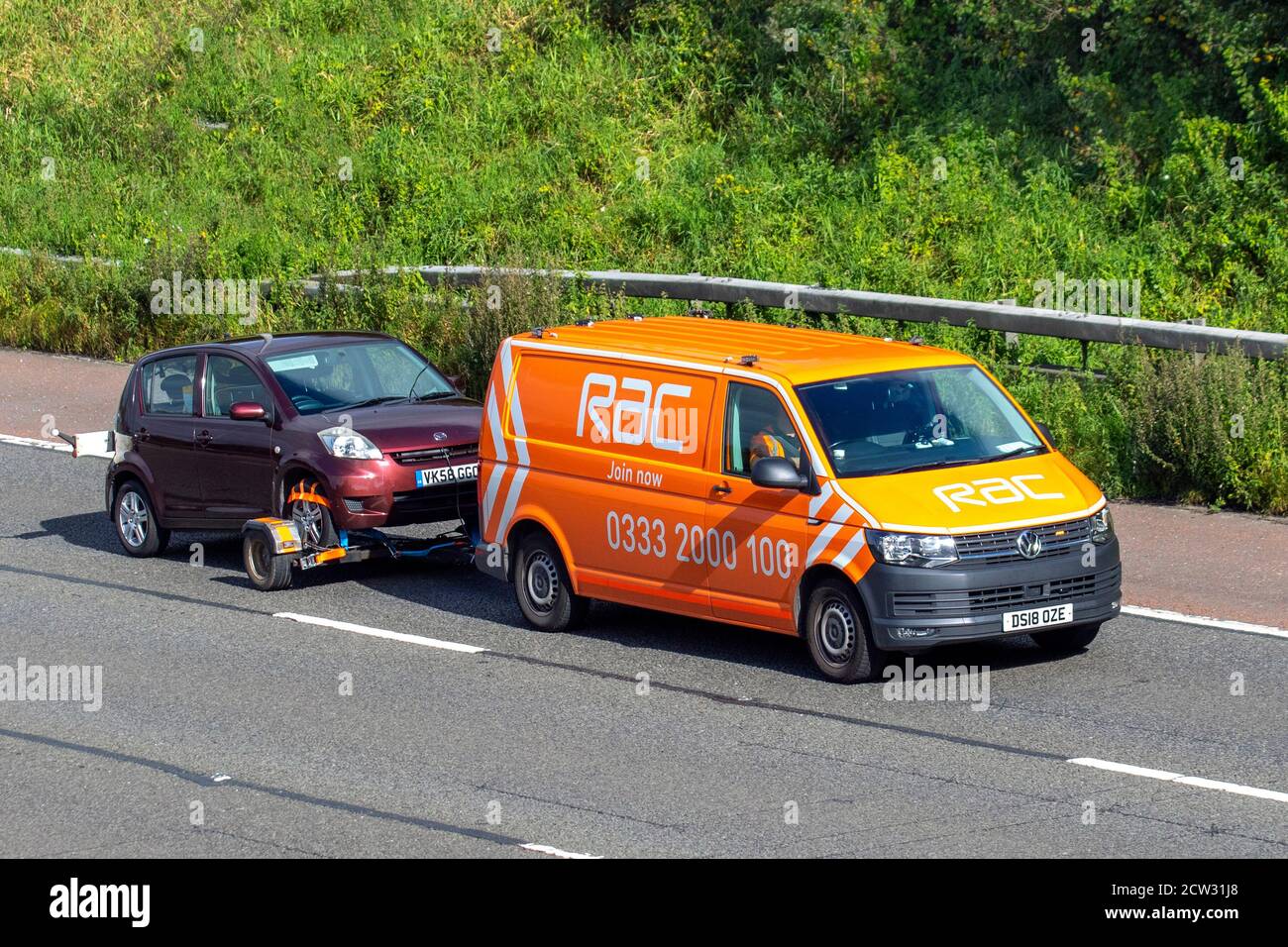 RAC towing car trailer breakdown van, Classic car roadside assistance,  delivery trucks, haulage, lorry, transportation, truck towing Daihatsu Sirion SE car, VW Vollkswagen transporter,  24hr vehicle recovery, delivery, transport industry, vehicle freight, on the M6 at Lancaster, UK Stock Photo
