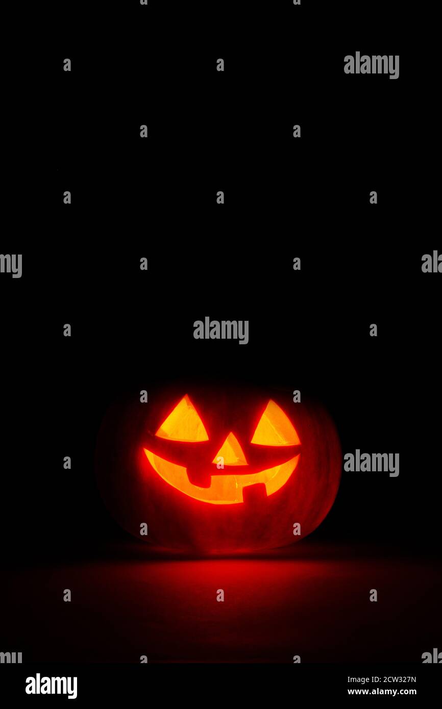 halloween pumpkin in the dark with candle inside, black background with copy space Stock Photo