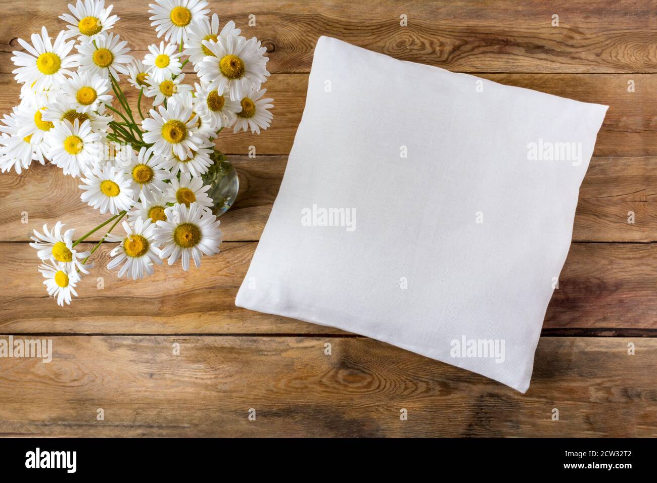 Square cotton pillow mockup with daisy wildflowers. Rustic linen