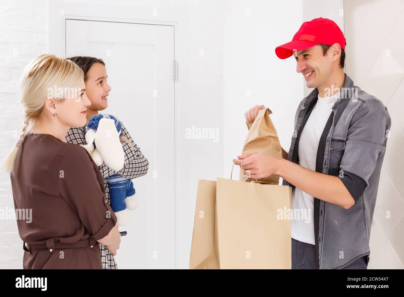 mother and daughter receive order from delivery man, delivery of toys