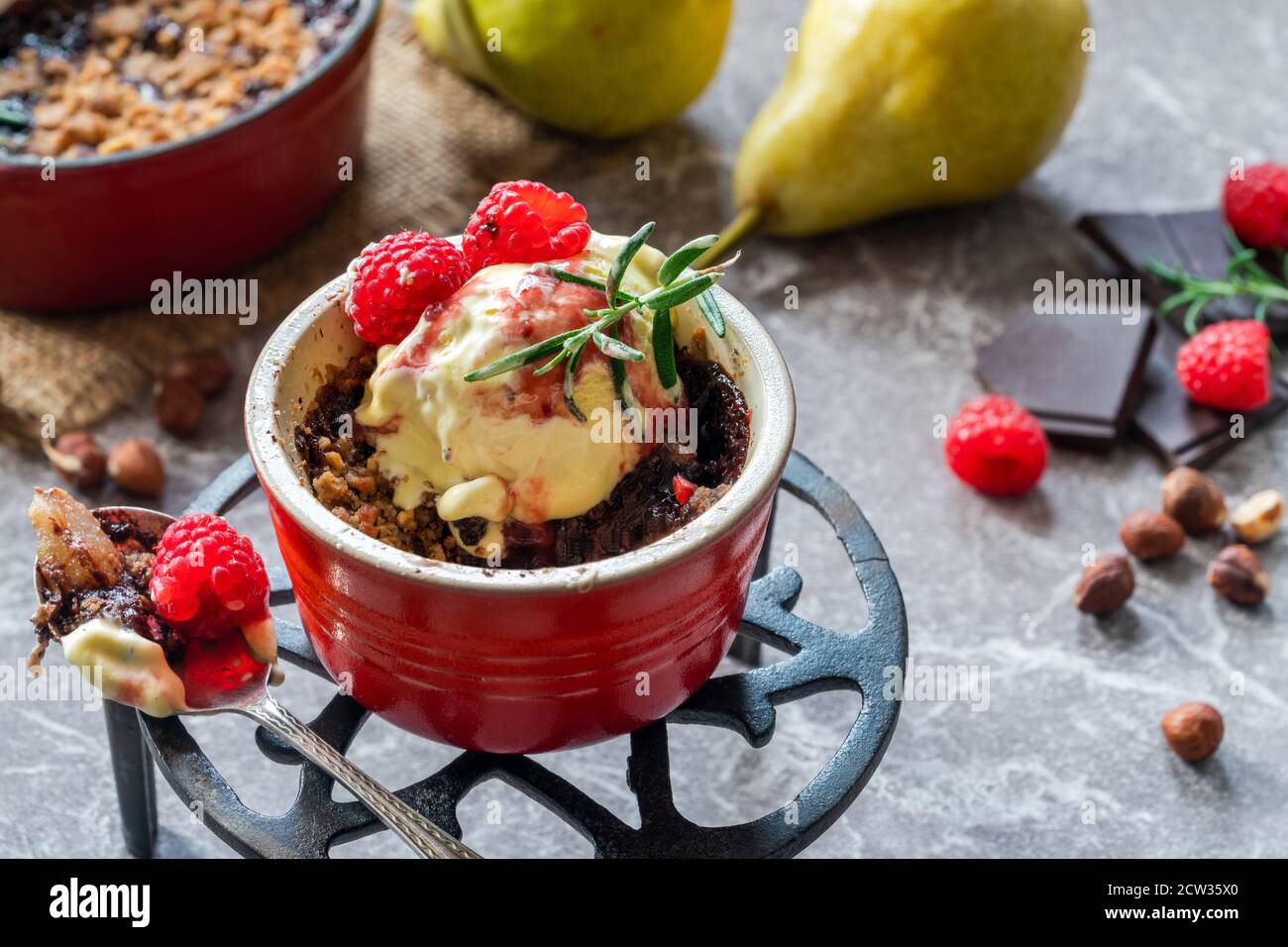 Pear crumble dessert with chocolate, hazelnuts, icecream and raspberry ...