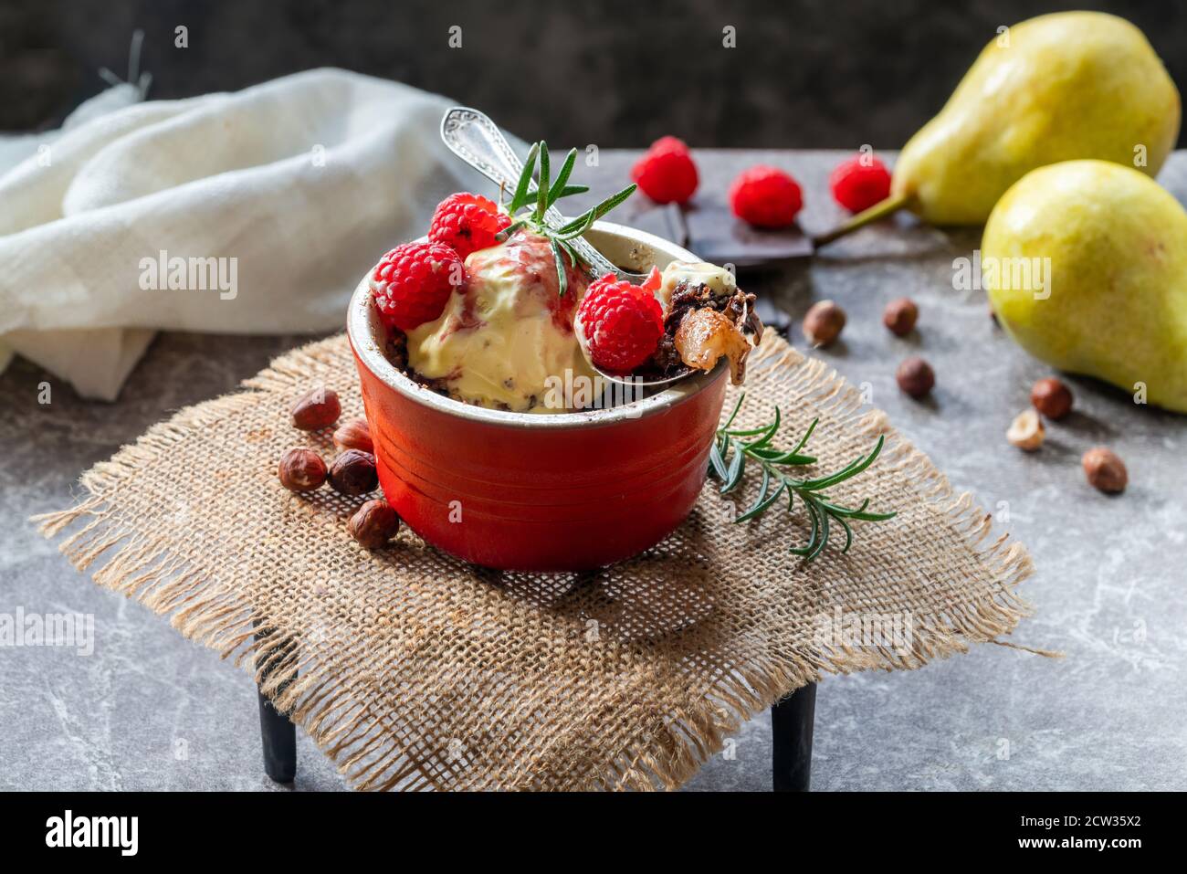 Pear crumble dessert with chocolate, hazelnuts, icecream and raspberry ...