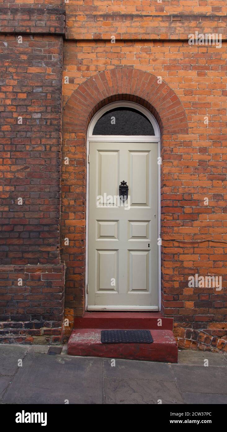 Old English Georgian door set in red brick house with step in front Stock Photo