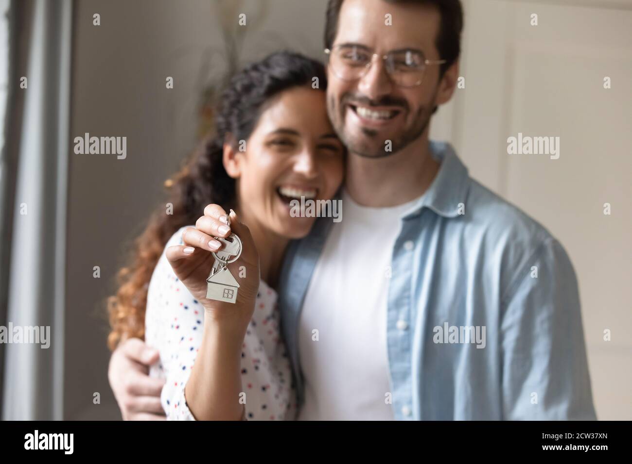 Close up of excited couple buyers show house keys Stock Photo