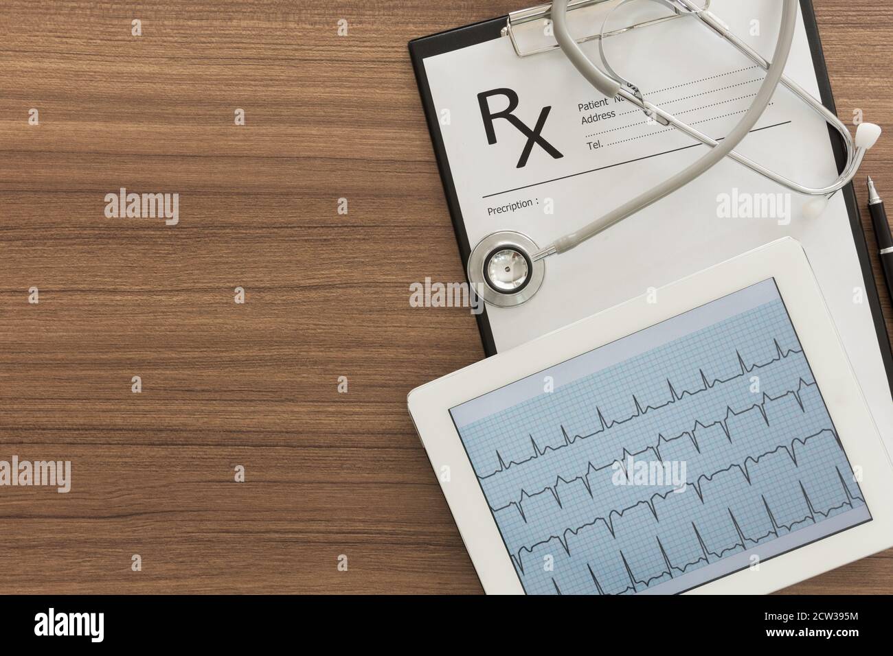 Cardiograph, ekg, electrocardiogram heart showing in tablet computer and RX medical documents on desk of doctor. Concepts of cardiologist and heart he Stock Photo